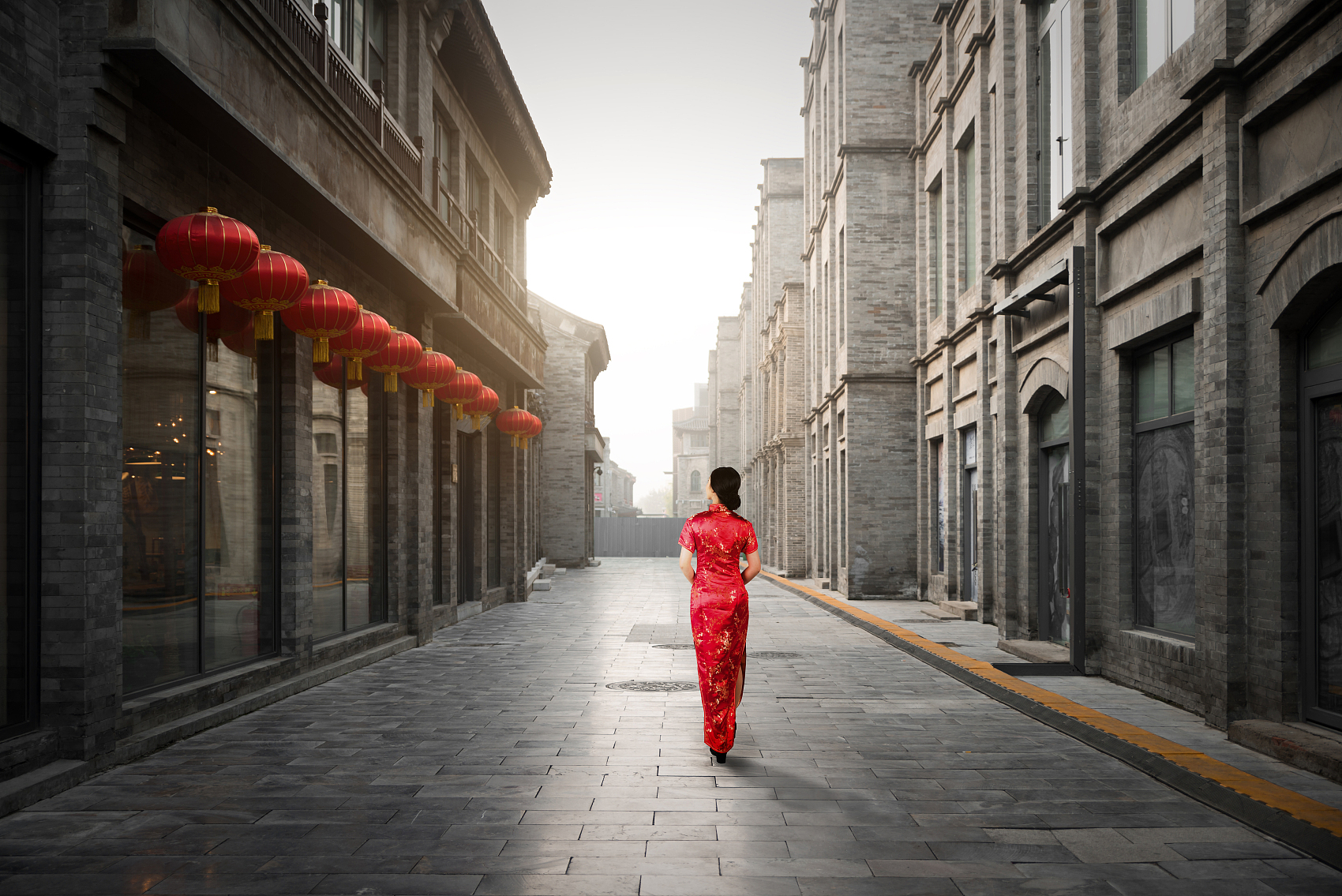 中国北京胡同里穿着传统中国服装的亚洲年轻女子。