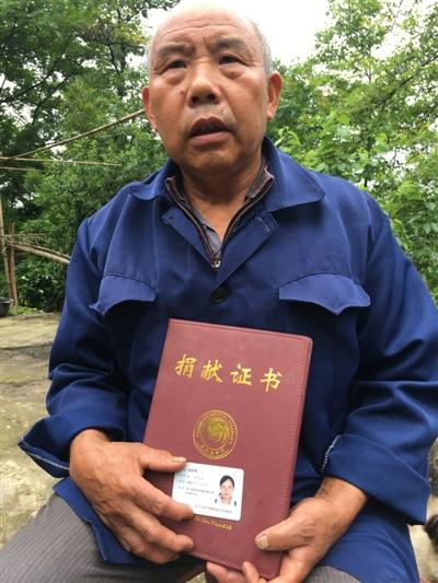 杨正贵怀抱女儿的身份证和捐献证书