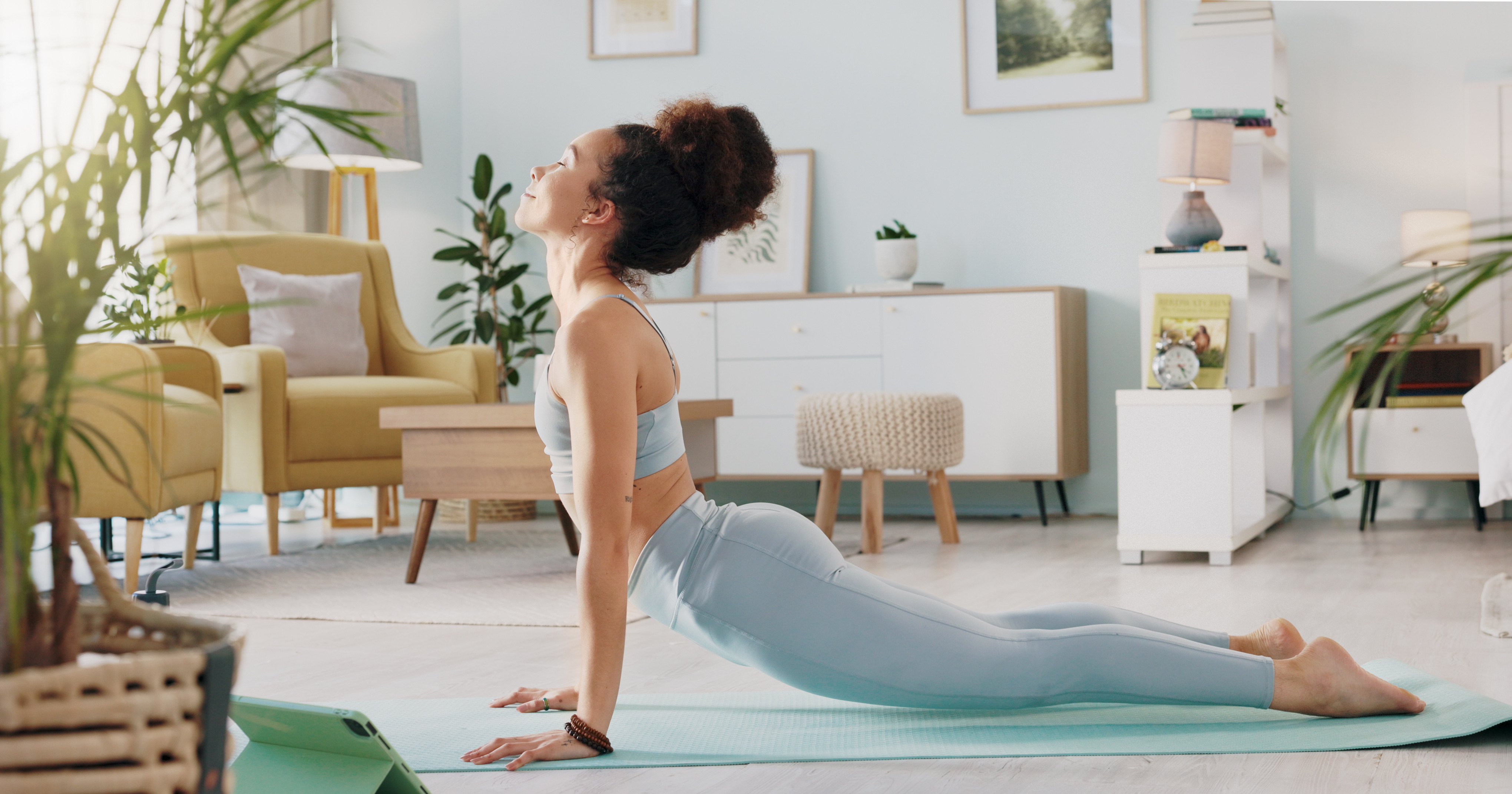 摄图网_330463649_健身 瑜伽或冥想伸展运动的女人在她家的客厅里锻炼 在训练 锻炼或健康时使用禅宗普拉提以保持健康的脉轮焦点 心态或平衡的女孩运动员（企业商用）