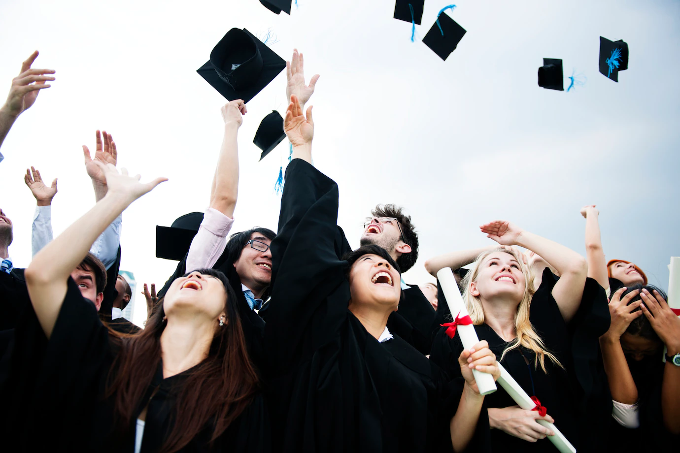 group-diverse-grads-throwing-caps-up-sky_53876-56031